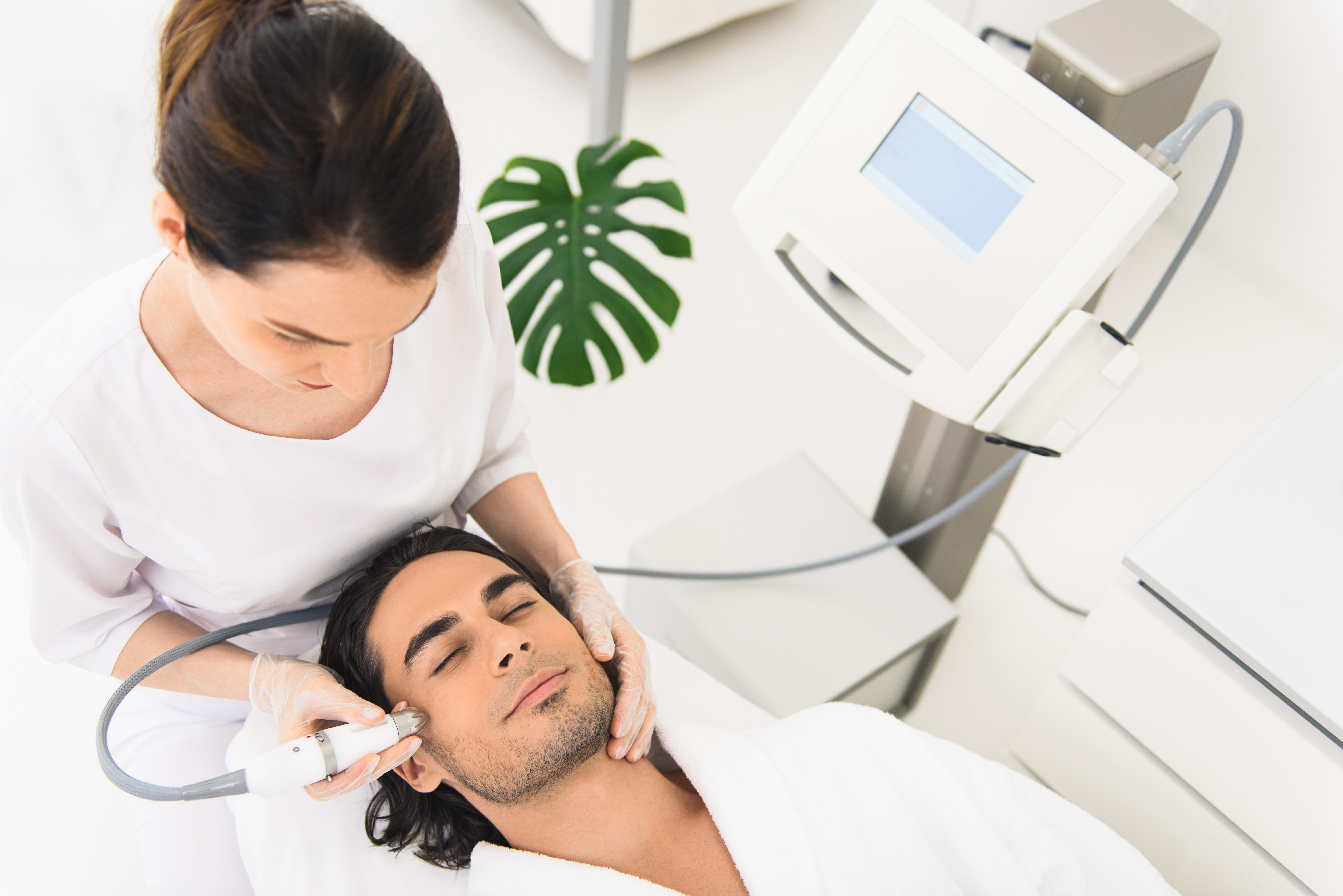male client having laser facial treatment in beauty salon